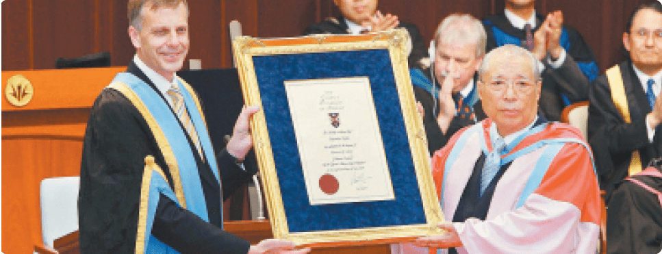 Presidente Ikeda (à dir.) recebe do então presidente da Universidade Queen’s Peter Gregson o título de doutor honorário da instituição (Tóquio, Japão, maio 2009).
